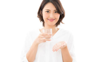 女性用サプリメントを飲む女性