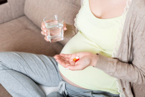 サプリメントを飲む妊娠中の女性